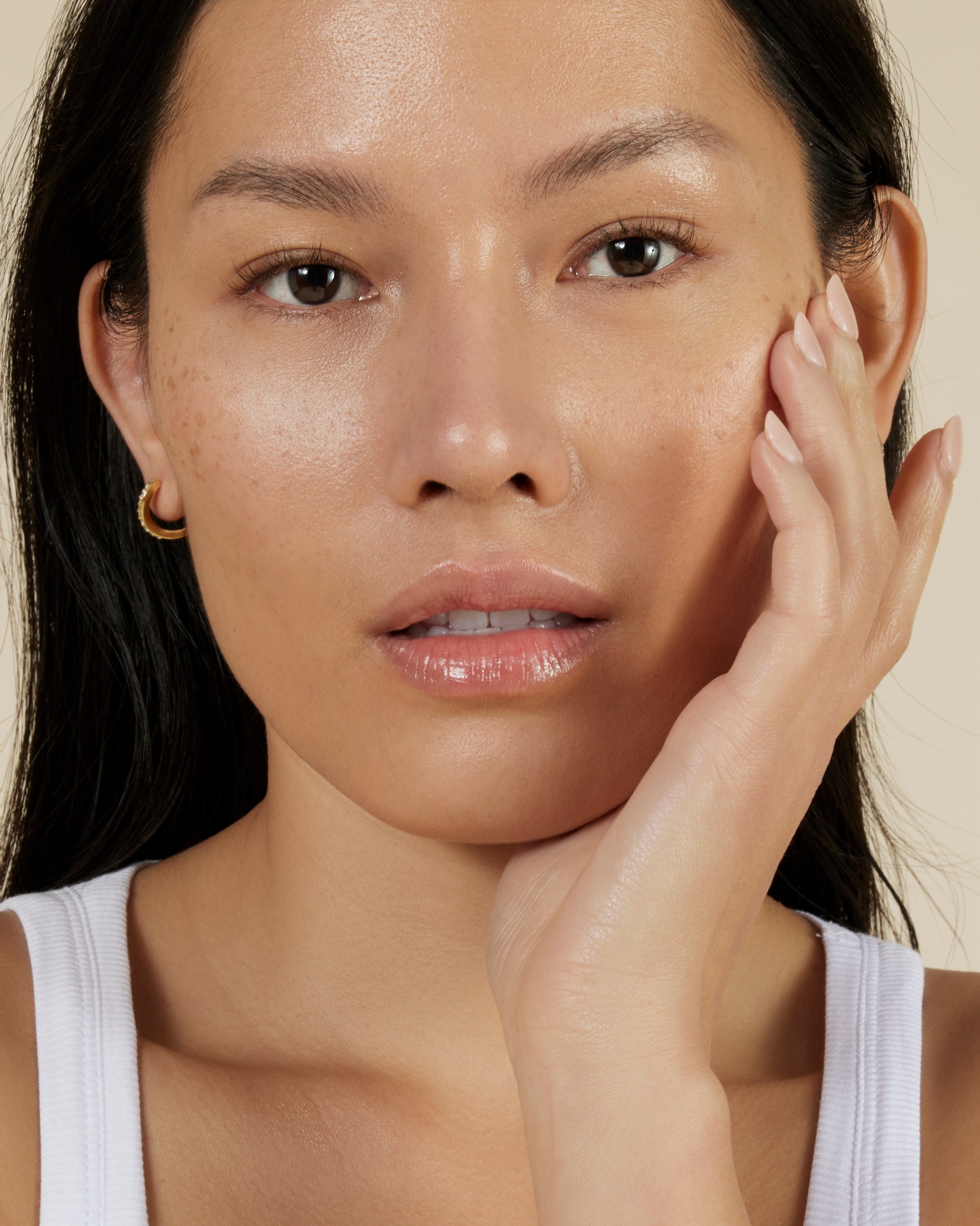 Close up of young women moistursing face with phorus hyperpigmentation serum