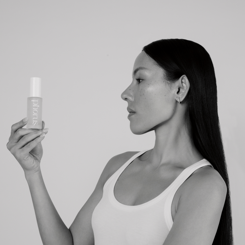 Black and white image of young women holiding phorus hyperpigmentation serum